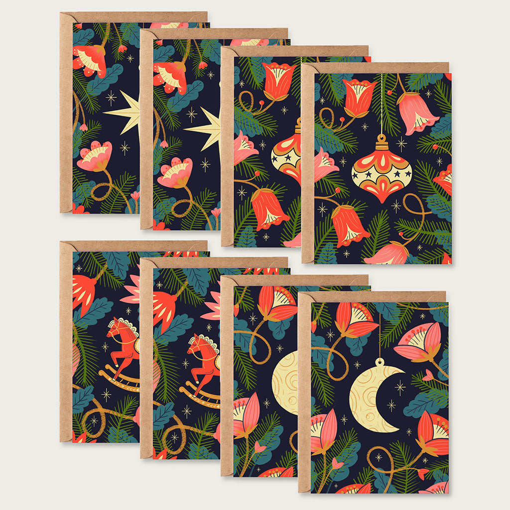 The Christmas Card Set include eight holiday cards printed with vegetable-based inks on sustainable car dstock, featuring floral, star, moon, and rocking horse designs. Each blank card comes with a brown kraft envelope.