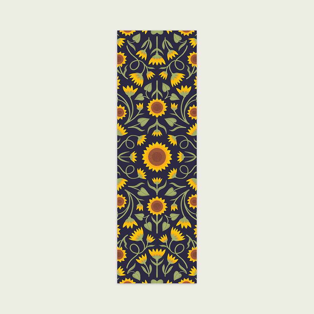 A perfect gift for book lovers, the Heritage Sunflower Bookmark features a symmetrical sunflower and foliage pattern in yellow, orange, and green on a dark background- radiating sunflower charm.