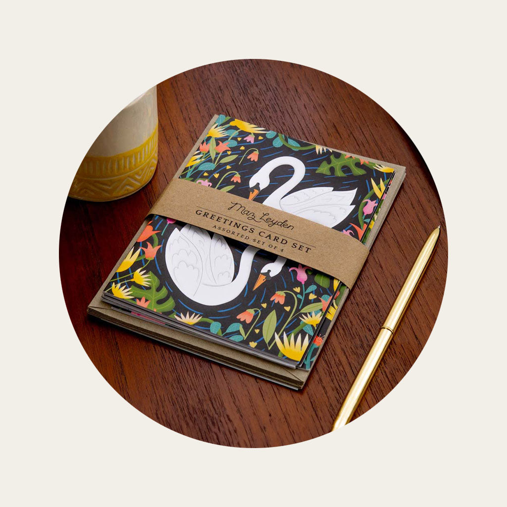 A stack of 4 of greetings cards, wrapped together with recycled paper envelopes. The top visible card has an illustrated swan design.