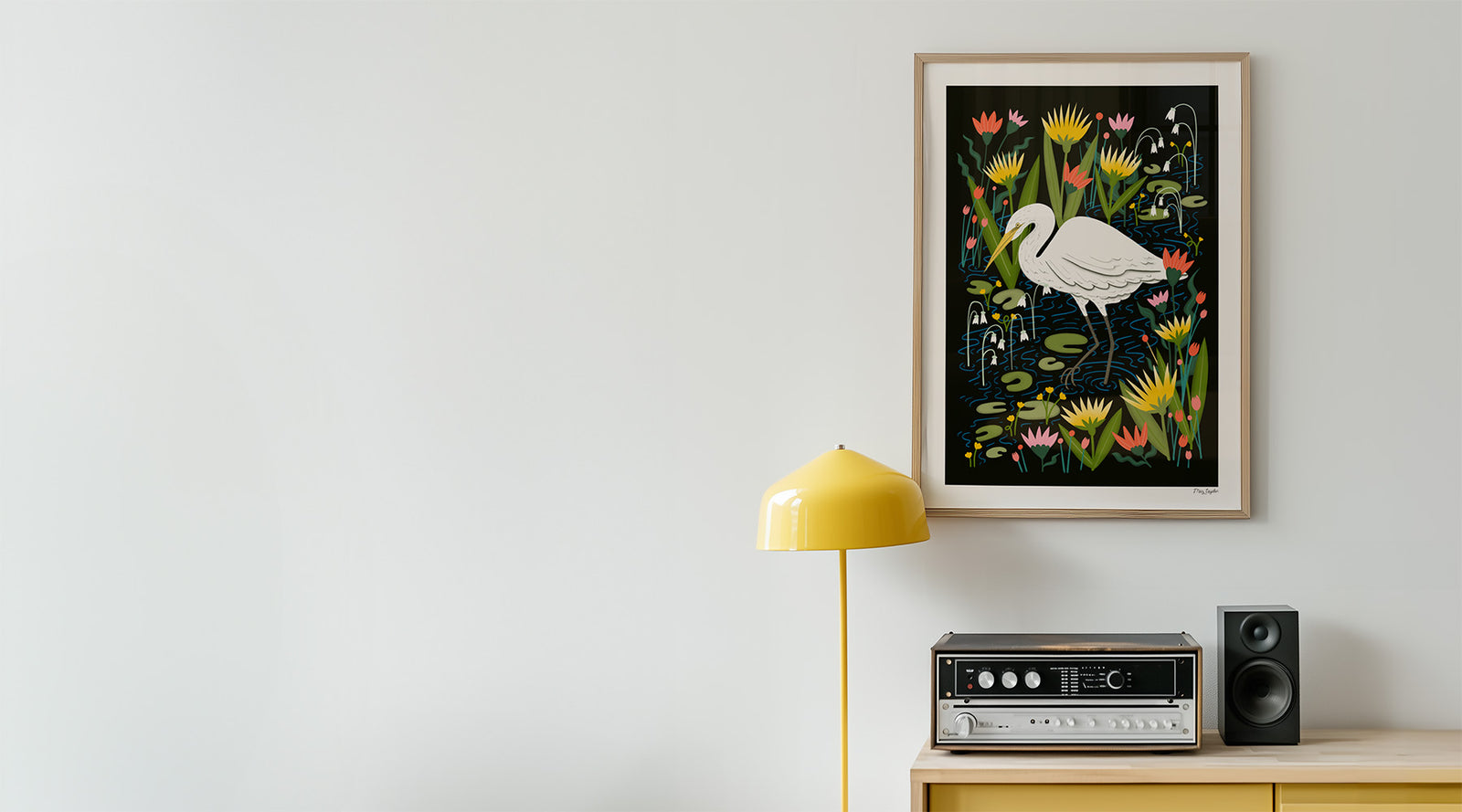 A fine art print with a great egret botanical design hanging on a wall above a sideboard.