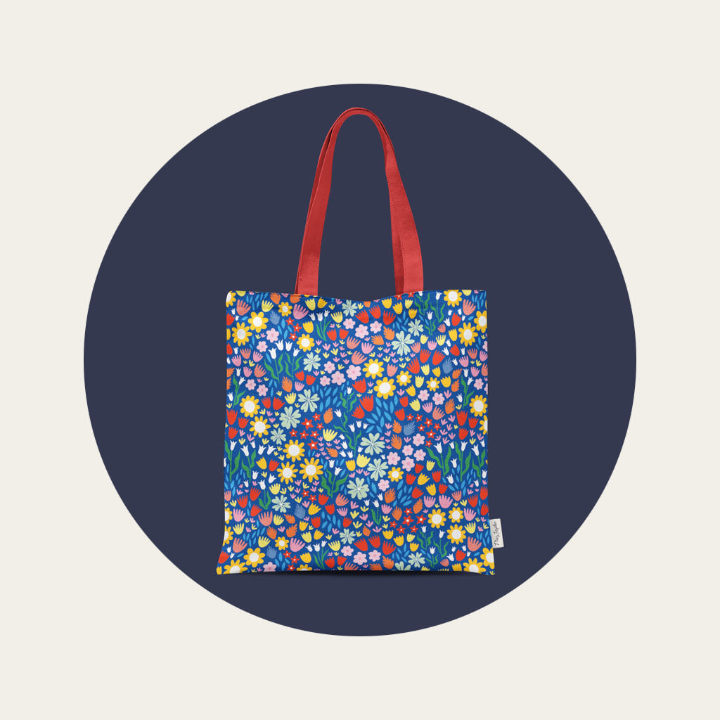 A cotton canvas tote bag with a bright multi coloured floral pattern.