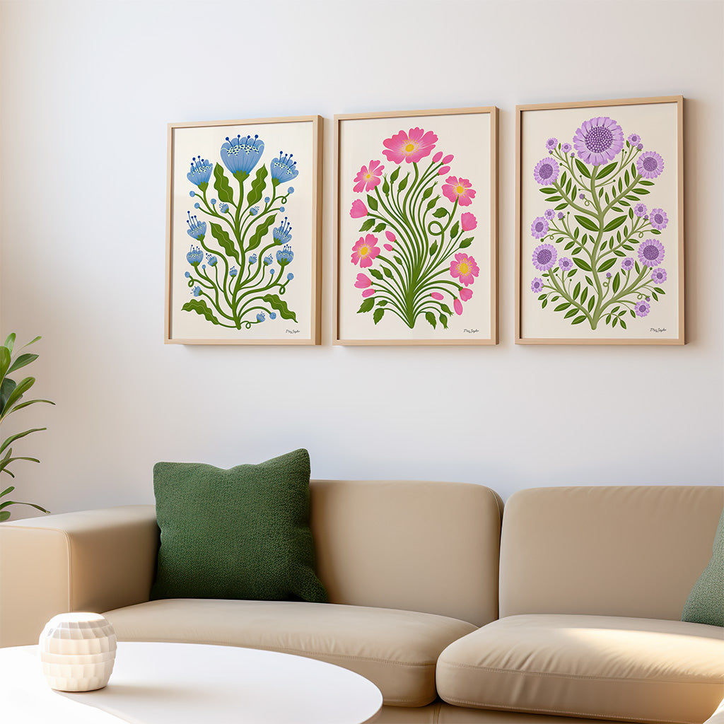 The Folk Flower set of three art prints features botanical designs each with green stems and leaves with colourful flowers, adding vintage charm to a light background.