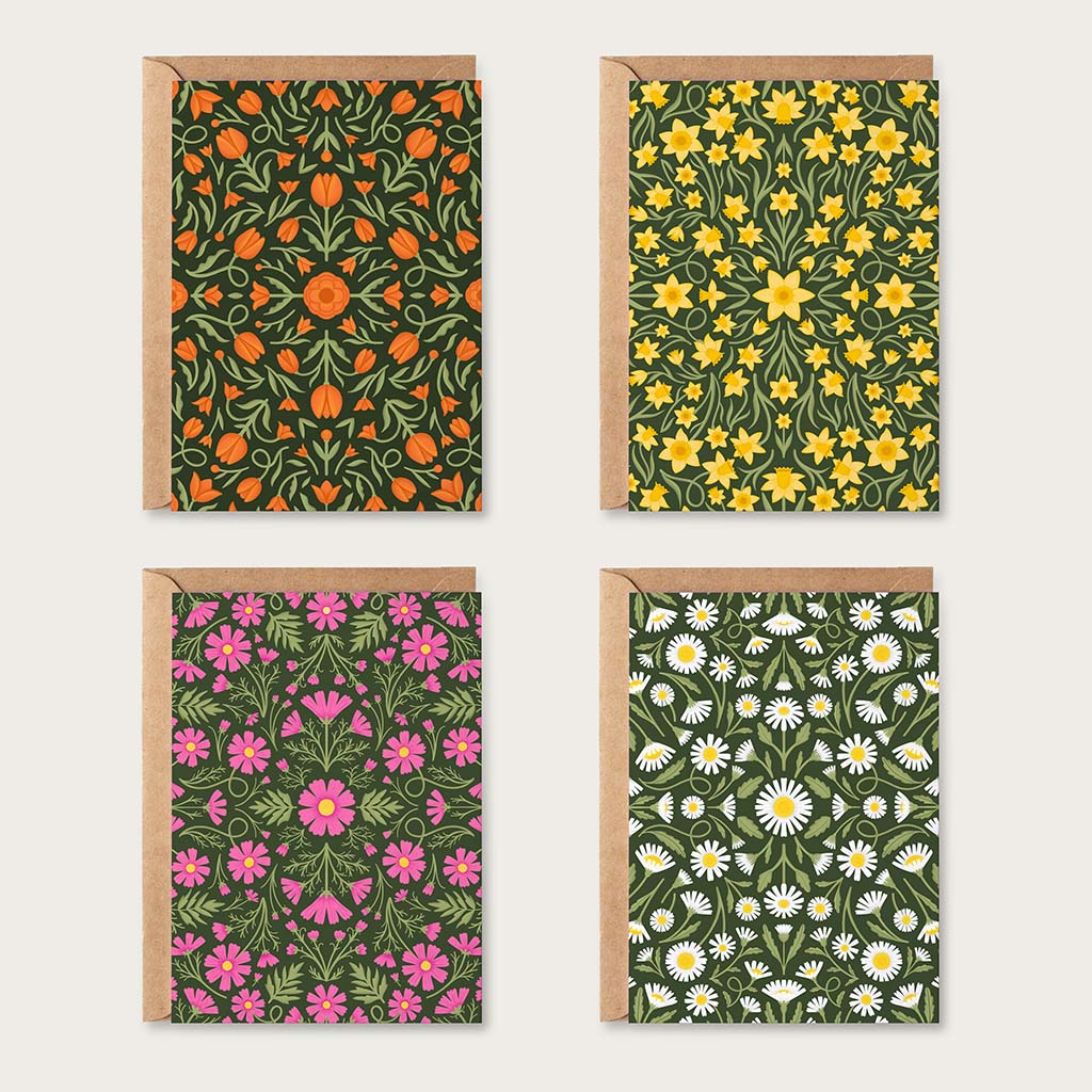The Heritage Florals Greetings Card Set features four sustainable cards: orange flowers, yellow flowers, pink flowers, and white daisies all on a green background, each with a kraft envelope.