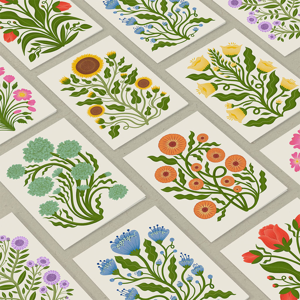 The Folk Flowers Greetings Card Set includes eight cards with vintage botanical designs in vibrant colours, each paired with a brown kraft envelope, they are displayed in two rows on a light background.