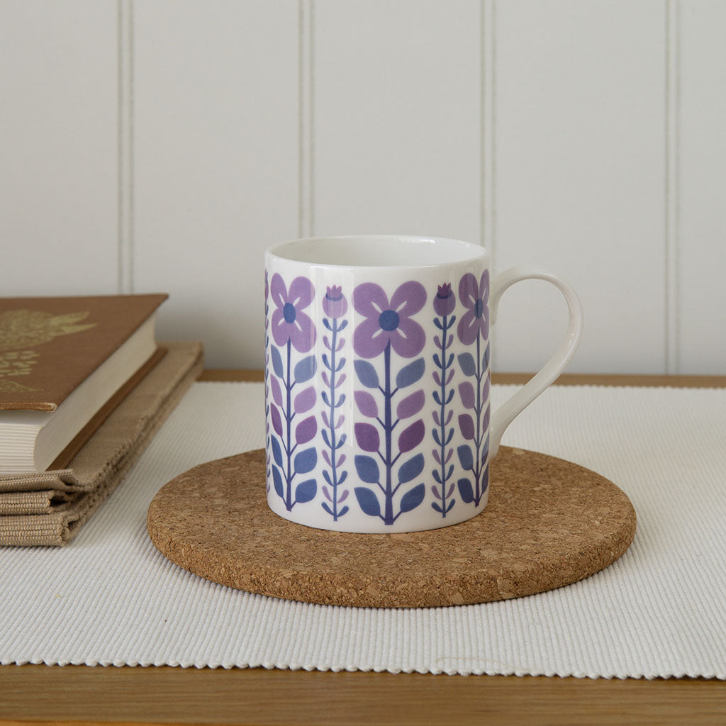 The Vintage Purple Mug is a white fine bone china mug with a handle, featuring a retro-inspired pattern of purple and blue flowers and leaves, combining vintage charm with modern durability for your favourite drinks.
