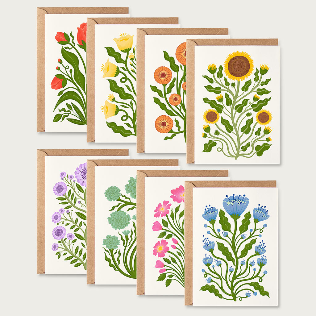 The Folk Flowers Greetings Card Set includes eight cards with vintage botanical designs in vibrant colours, each paired with a brown kraft envelope, they are displayed in two rows on a light background.