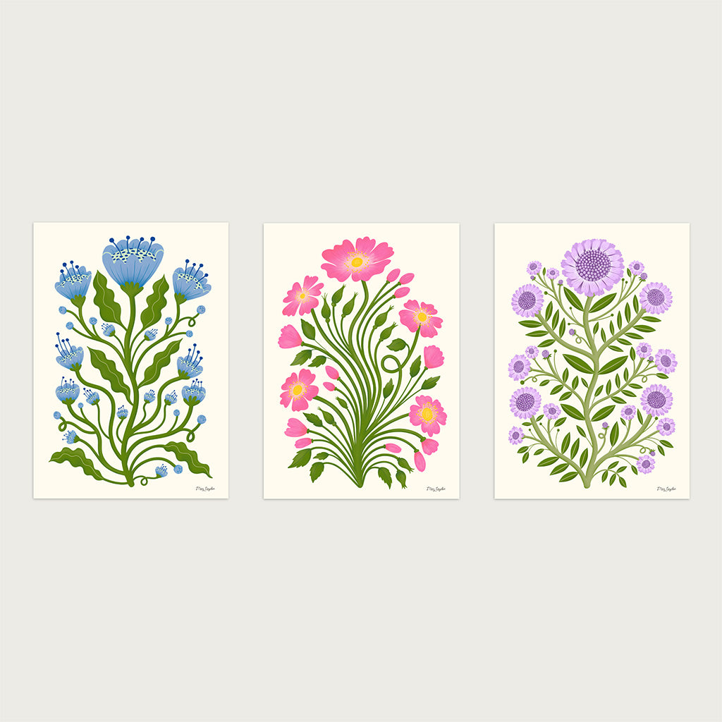 The Folk Flower set of three art prints features botanical designs each with green stems and leaves with colourful flowers, adding vintage charm to a light background.