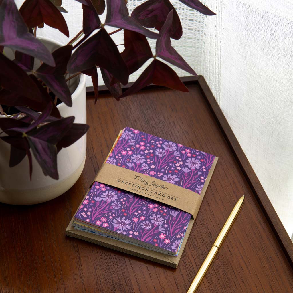 The Wildflower Bloom Greetings Card Set includes eight cards with envelopes, each showcasing a unique collection of British wildflowers in vibrant red, yellow, orange, green, blue, navy and purple.