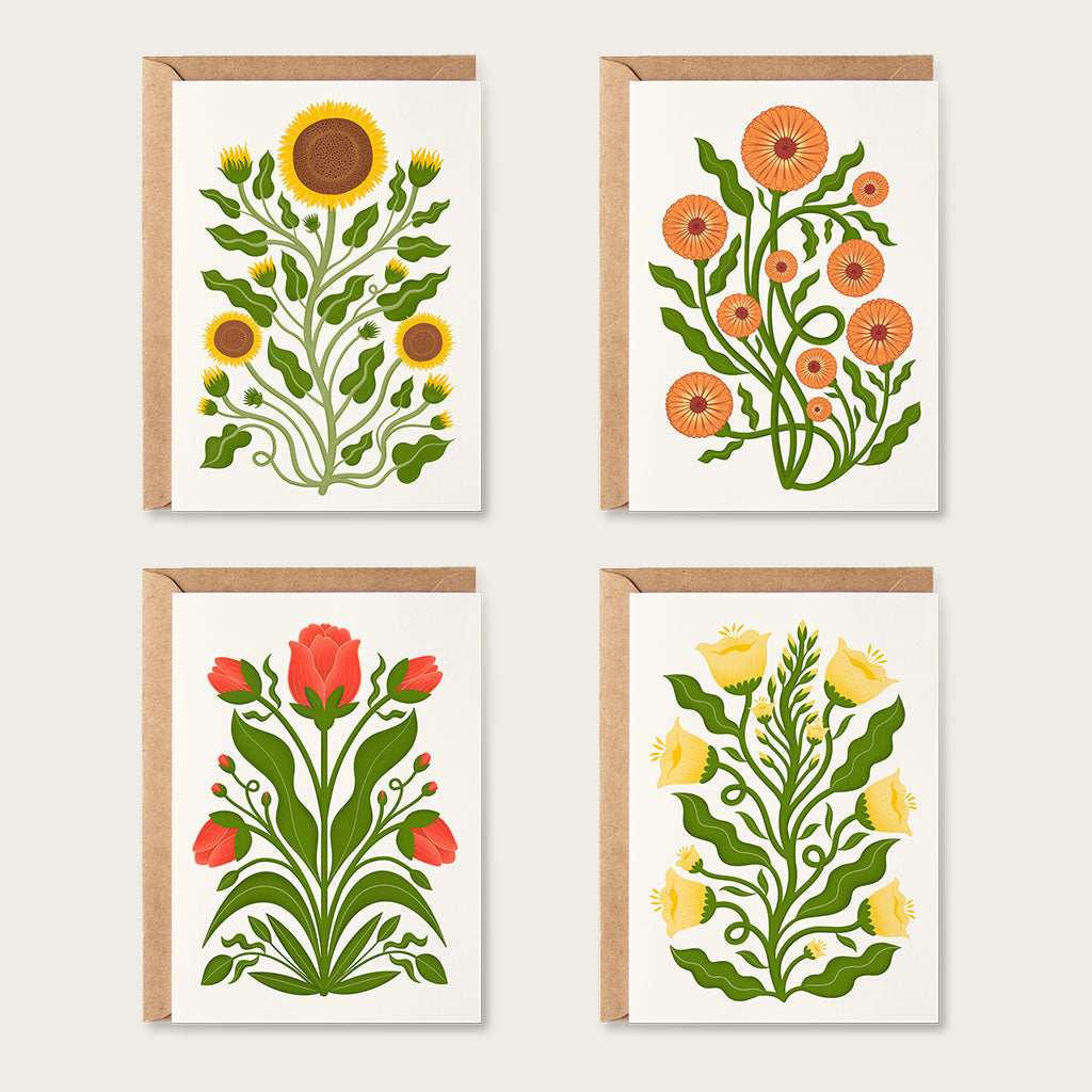 The Folk Flowers Greetings Card Set features illustrated cards with sunflowers, orange flowers, red tulips, and yellow bell-shaped blooms, each paired with a brown envelope.