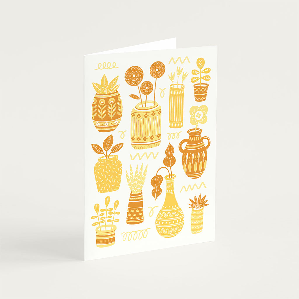 The Yellow Pots & Plants Greetings Card features illustrated yellow and orange cacti and succulents in pots and vases, arranged decoratively on a cream background—ideal for plant lovers.