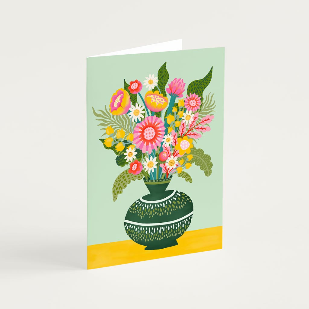 A Flower Vase Greetings Card featuring an illustrated bouquet in a vase with green leaves on a light background and yellow surface—ideal for writing your special message.