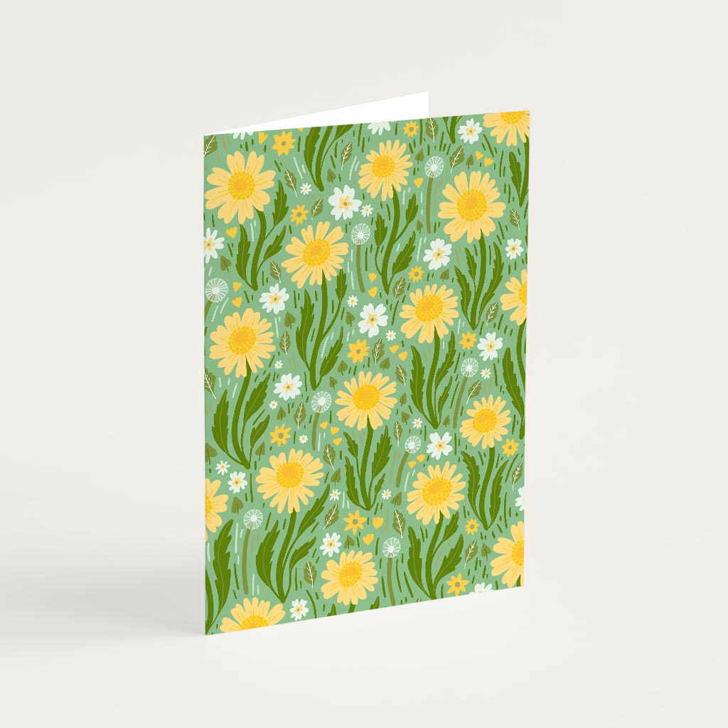 The Green Wildflowers Greetings Card stands upright with a green background and features yellow and white British wildflowers with green leaves.