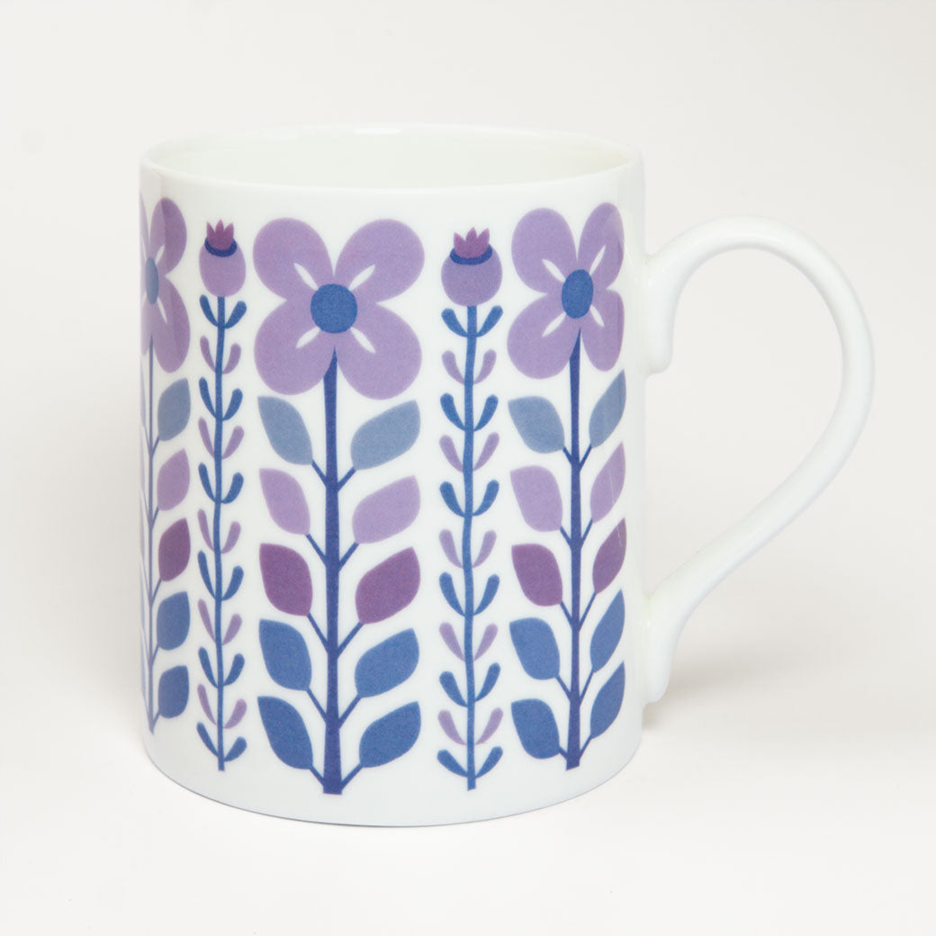 The Vintage Purple Mug is a white fine bone china mug with a handle, featuring a retro-inspired pattern of purple and blue flowers and leaves, combining vintage charm with modern durability for your favourite drinks.