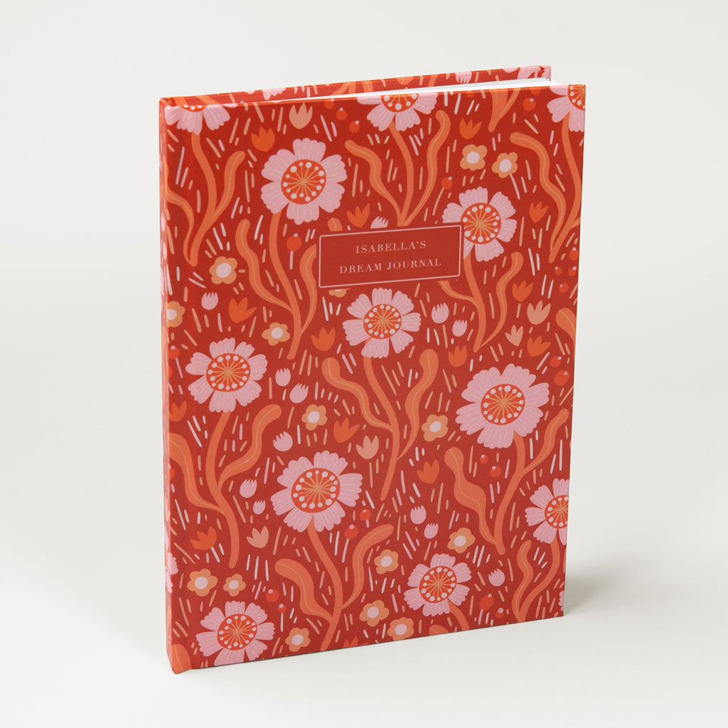 The Red Wildflowers Personalised Notebook is a hardcover with delicate red and pink British wildflower illustrations and a customisable label on the journal's front cover.