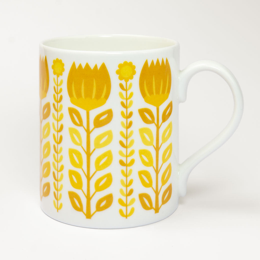 The Vintage Yellow Mug is a fine bone china white ceramic mug with a handle, featuring retro yellow illustrated flowers and leaves on a plain background—perfect for adding cheerful charm to your collection.